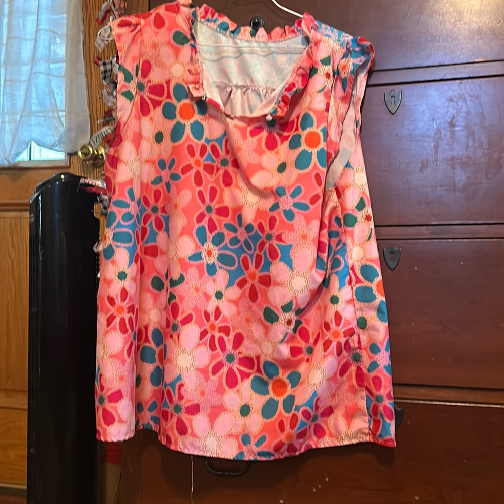 A flowered 60’s hip top, with ruffled lined neck and a button at the neck